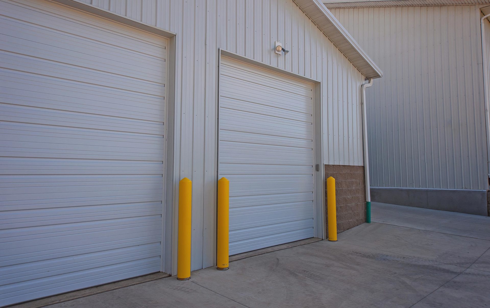 White commercial building with two white overhead doors
